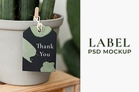 Label mockup psd on a gray pot with a plant