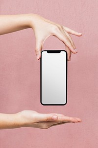 Blank white smartphone screen, woman holding on pink background