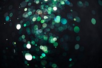 Green glitter  bokeh sequin confetti on black background