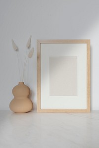 Empty wooden frame with dried flowers in a gourd vase