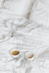 Two cups of coffee on the bed