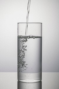 Macro shot of water pouring into a glass