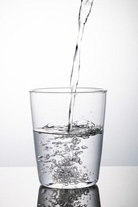 Macro shot of water pouring into a glass