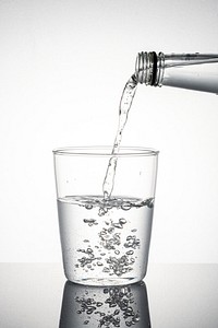 Macro shot of water pouring into a glass