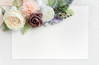 Blank white card with flowers on white fabric textured background