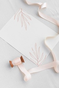 Botanical white card mockup with a pink ribbon roll