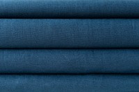 Stack of folded aegean blue woven fabric textured background