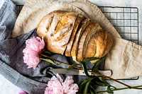 Homemade bread with pink peonies flatlay. Visit <a href="https://monikagrabkowska.com/" target="_blank">Monika Grabkowska</a> to see more of her food photography.