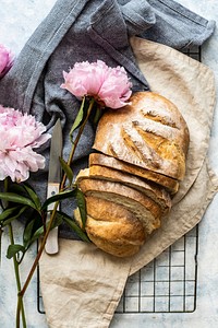 Homemade bread with pink peonies flatlay. Visit <a href="https://monikagrabkowska.com/" target="_blank">Monika Grabkowska</a> to see more of her food photography.
