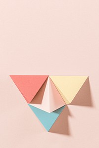 3D pastel pyramid paper craft on a pink background