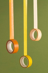 Yellow and orange rolls of tape on an olive green background 