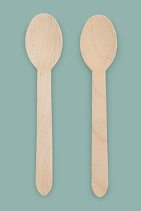 Natural wooden spoons on green background