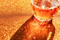 Whisky in a glass on a golden background 