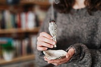 Woman burning sage smudge to cleanse the house