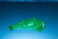 Crumpled plastic bottle polluting the ocean