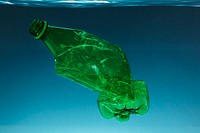 Crumpled plastic bottle polluting the ocean