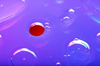 Oil drops floating on water colorful background