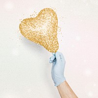 Gloved hand holding a glittery gold heart shaped balloon mockup