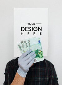 Gloved hands holding a blank paper mockup with banknotes