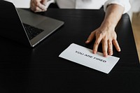 Boss handing a you are fired note to his employee during the COVID-19 pandemic