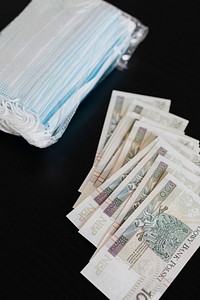 Polish Zloty banknotes and face masks on a black table