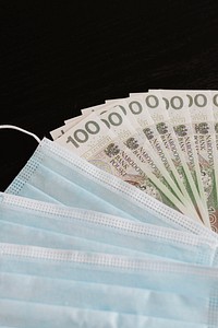 Polish Zloty banknotes and face masks on a black table