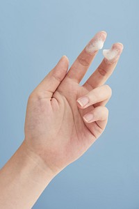 Hand with white facial foam cleanser