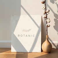 Cotton flower in a vase by a blank card on a wooden floor