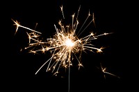 Burning sparkler design element on a black background