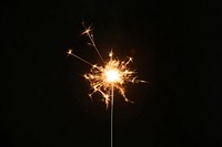 Burning sparkler on a black background wallpaper