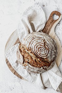 Loaf of homemade bread on wooden cutting board