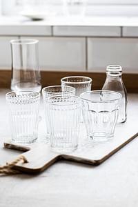 Transparent glassware on a wooden cutting board