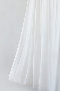 White drapery hanging from a curtain rod
