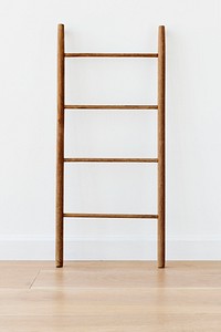 Wooden ladder against a white wall