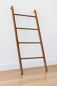 Wooden ladder against a white wall