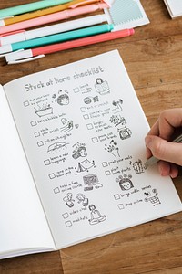 Girl doodling and making a checklist in a notebook