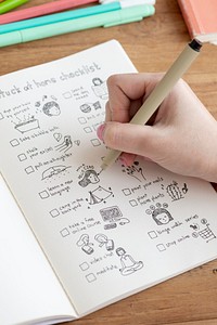 Girl doodling and making a checklist in a notebook