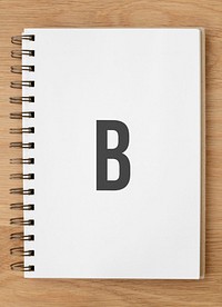 White ruled notebook mockup on a wooden table