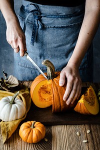 Person cutting Halloween pumpkin closeup