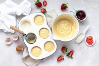 Mini strawberry cupcakes in a baking tray on a kitchen counter 