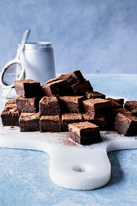 Chocolate ganache truffle squares dusted with cacao on a cutting board