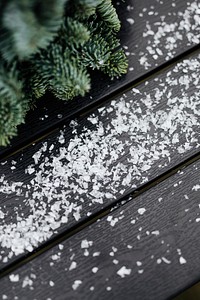 Fresh pine branch and snowflakes on the table