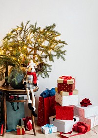Presents by a wooden chair with a Christmas tree 
