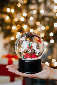 Christmas snow globe in her hand