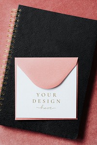 Pink envelope mockup on a black notebook