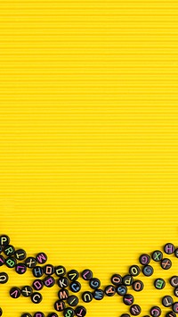 Black alphabet beads yellow phone background