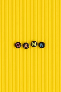 DAMN beads text typography on yellow