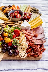 Charcuterie board with cold cuts, fresh fruits and cheese close up