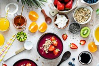 Preparing acai bowl in flat lay style with tropical fruits and grains