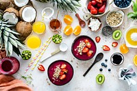 Preparing acai bowl in flat lay style with tropical fruits and grains